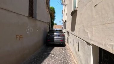 Araba ve scooter dar geçitte geziniyor