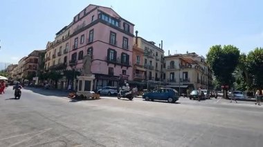 Kalabalık bir caddede motosikletler ve arabalar