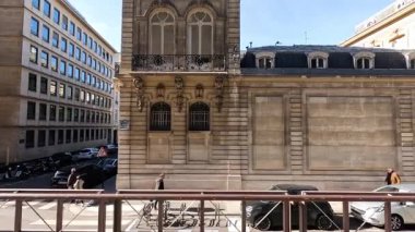 İnsanlar tarihi binanın önünden geçiyorlar.