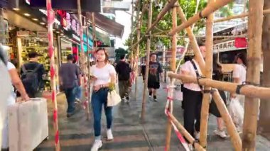 Kalabalık bir caddede yürüyen yayalar.