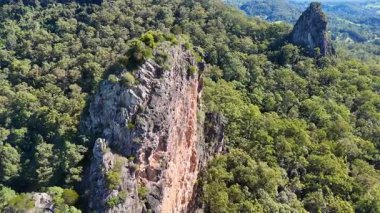 Avustralya 'daki Nimbin Kayaları' nın hava görüntüleri, parlak gün ışığı altında yemyeşil okaliptüs ormanları arasında yükselen ryolit oluşumlarını gösteriyor.