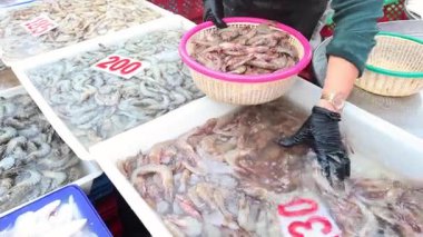 Pazarda karidesleri sepetlere ayıran kişi