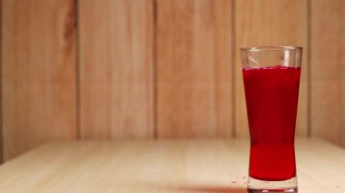 Masada bir bardak kırmızı meşrubat.