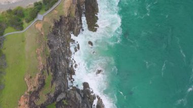 Byron Körfezi 'ndeki kayalık kayalıklara dalgalar çarpıyor.