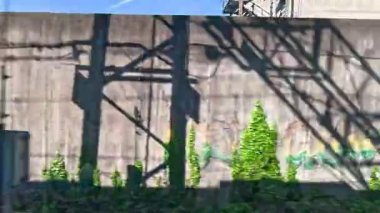 Grafiti kaplı duvarlar hareket halindeki bir trenden görülüyor.