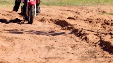 Kumlu bir off-road pistinde gezinen motosikletçi