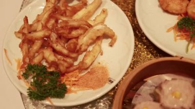 Cam sehpanın üzerinde çeşitli Çin yemekleri ve geleneksel Çin mutfağı var.