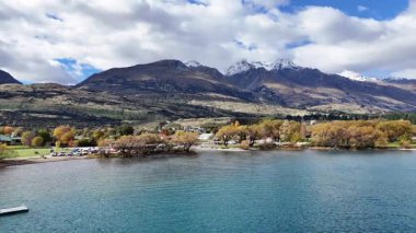Hava görüntüleri Glenorchy 'nin sakin manzarasını dağlarla, gölle ve parçalı bulutlu bir gökyüzünün altında canlı sonbahar yapraklarıyla yakalar.