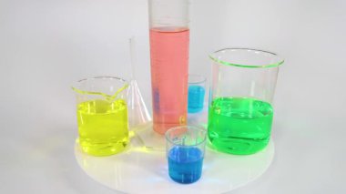 Laboratuvar şişelerinde çeşitli renkli sıvılar var.