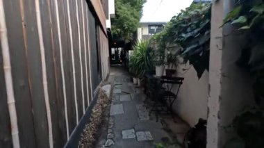 Bitkilerin ve ahşap duvarların olduğu dar bir yol.