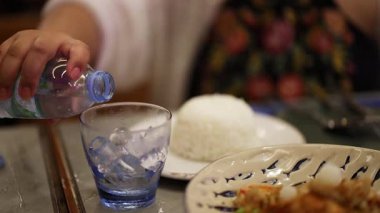 Thai yemeğinin yanında bardağa su döküldü.
