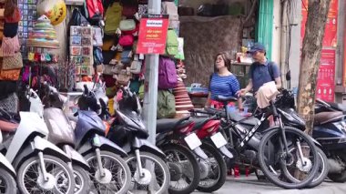 Motosiklet ve sokak dükkanlarının yakınındaki insanlar