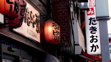 Geleneksel bir kurumun dışında parlayan Japon fenerleri.