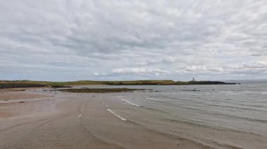 Dalgalar yavaşça kumlu kıyıya çarpar