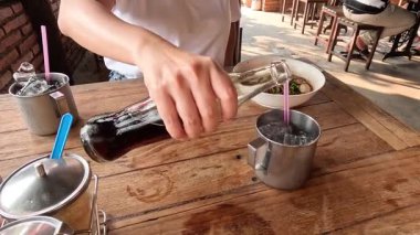 Bir içkiyi buzla, otlarla karıştırır,