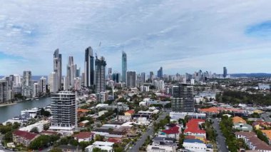 Yüksek çözünürlüklü insansız hava aracı görüntüleri Avustralya 'nın Gold Coast üzerinde yükselir, modern gökdelenleri, su yollarını ve şehir manzarasını gün ışığı altında düzgünce yukarı doğru hareket eden kamera hareketiyle ortaya çıkarır.