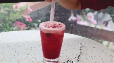 Saman ile kırmızı bir içeceği karıştırmak