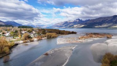 Havadan çekilen görüntüler Glenorchy 'nin dinamik bulut örtüsü ve parlak ışık altında sakin nehir ve dağ manzarasını yakalıyor.
