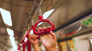 Hareket eden bir trende elleri kavrayan eller.