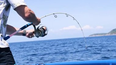 Balıkçı teknede balık tutuyor.