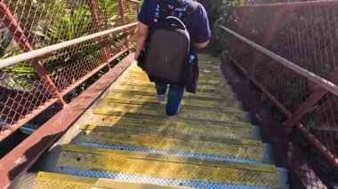 Yeşilliklerle çevrili merdivenlerden inen kişi