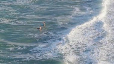 İki çocuk, Avustralya 'nın Gold Coast kentindeki okyanus dalgalarında oynamaktan zevk alır. Güpegündüz bir drondan yakalanırlar.