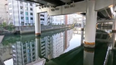 Şehir köprüsünün altından akan sakin bir su yolu