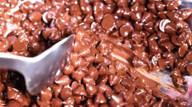 Bir kasede çikolata parçaları karıştıran kaşık.