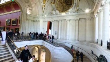 Ziyaretçiler görkemli bir merdivenden inip çıkıyorlar.