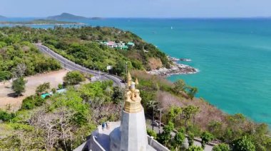 İnsansız hava aracı görüntülerinde Phuket, Tayland 'daki Promthep Burnu Deniz feneri, yemyeşil ve turkuaz sularla çevrili.