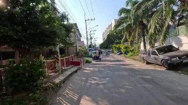 Şehir yolunda yürüyen araçlar ve yayalar.