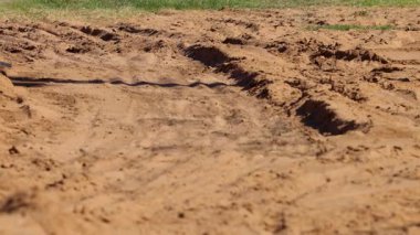 Motosiklet engebeli toprak yolda ilerliyor