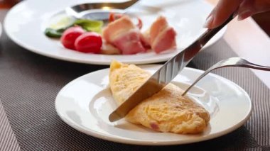 Bir tabakta kabarık bir omlet kesiyorum.