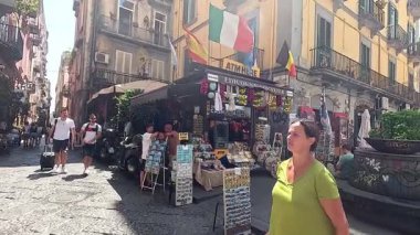 Canlı bir sokak pazarında yürüyen turistler