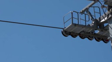 Açık mavi gökyüzünde hareket eden kablo araba