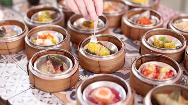 Eller bambu sepetlerinden dim sum seçiyor