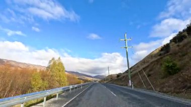 50 saniyelik bir zaman aralığı Wanaka 'nın göz kamaştırıcı dağlık arazisini açık mavi gökyüzünün altında yakalıyor.