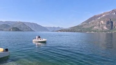 İnsanlar manzaralı dağ manzaralı tekneler kullanıyorlar.