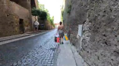 Alışveriş torbalarıyla yürüyen biri.