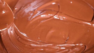Yumuşak eritilmiş çikolata sürekli karıştırılıyor.