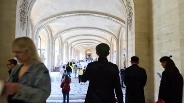 Louvre Müzesi 'nin büyük koridorunda yürüyen insanlar.