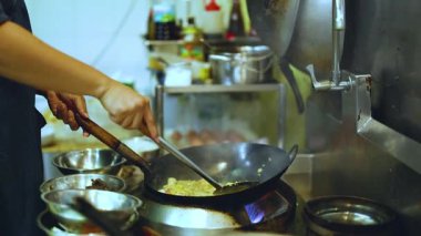 Şef Bangkok 'ta tavayla ustalıkla yemek pişiriyor.