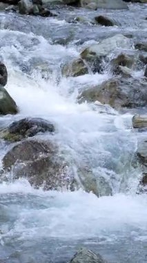 Temiz dağ akıntısı gün ışığında düz kayaların üzerinden geçer. Sabit kamera hareketleri ve doğal ışıklandırmayla yakalanır. Temiz ve sakin bir açık hava atmosferi yaratır.