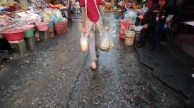 Yoğun bir ıslak pazarda gezinen kişi