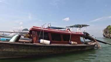 Huzurlu bir gölde ahşap bir teknede yol alan biri.