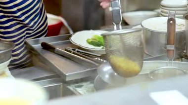 Şef sebzeli şehriye çorbası yapıyor.