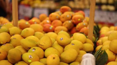 Market vitrininden portakal seçen kişi