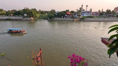 Resimli bir nehir boyunca bir tekne seyahat eder.