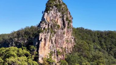 Görkemli Nimbin Kayaları 'nı açık mavi gökyüzüne yansıtan hava görüntüleri engebeli dokularını ve çevreleyen yeşillikleri vurguluyor.