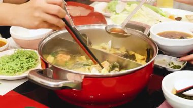 Arkadaşlar birlikte güveç yerler.